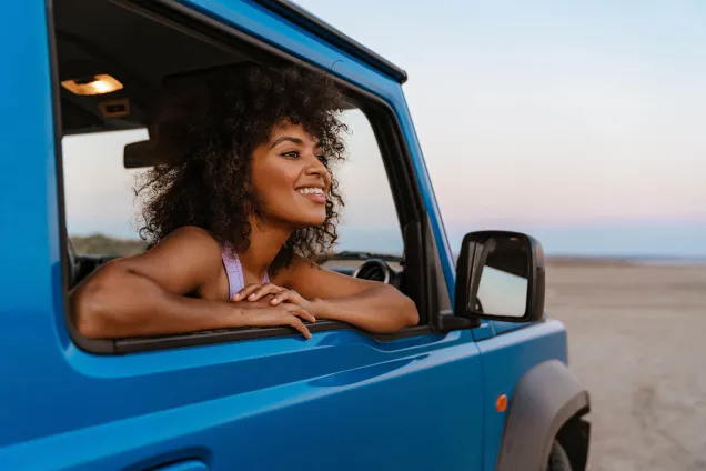 woman passenger looking out of blue car 